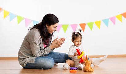 Image showing mother and baby daughter playing with pyramid toy