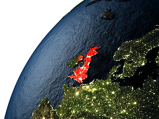Image showing United Kingdom in red on Earth at night