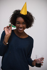 Image showing black woman in party hat blowing in whistle