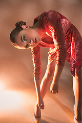 Image showing High Fashion model woman in colorful bright lights posing in studio,