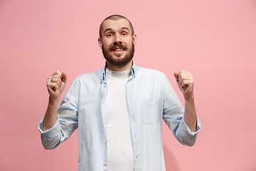 Image showing The happy business man standing and smiling against pink background.