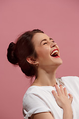 Image showing The happy business woman standing and smiling against pink background.