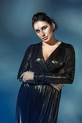 Image showing Fashion young woman in black stilish dress. Glamour sexy model in fashion pose, stylish make-up, fashion heels.