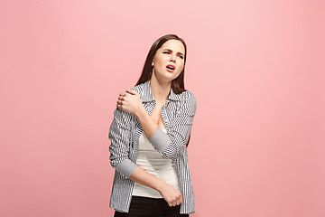 Image showing The shoulder ache. The sad woman with shoulder ache or pain on a pink studio background.