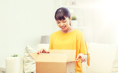 Image showing happy asian young woman with parcel box at home