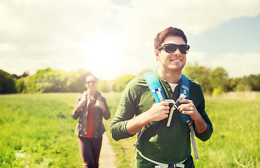 Image showing happy couple with backpacks hiking outdoors