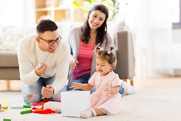 Image showing baby girl with birthday gift and parents at home 