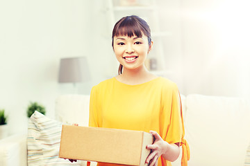 Image showing happy asian young woman with parcel box at home