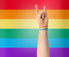 Image showing hand with gay pride rainbow wristband shows rock