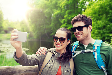 Image showing couple with backpacks taking selfie by smartphone