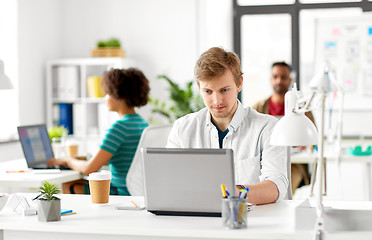 Image showing creative male office worker with laptop