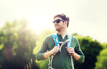 Image showing happy young man with backpack hiking outdoors