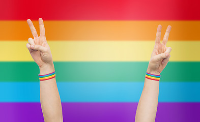 Image showing hands with gay pride rainbow wristbands make peace