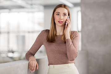 Image showing businesswoman calling on smartphone at office