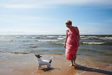 Image showing Woman and dog standing in sea