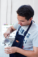 Image showing Barista pouring milk in cup