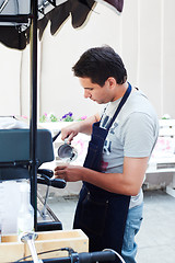 Image showing Barista pouring milk in cup