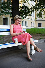 Image showing Adult woman using smartphone on bench