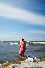 Image showing Woman and dog standing in sea