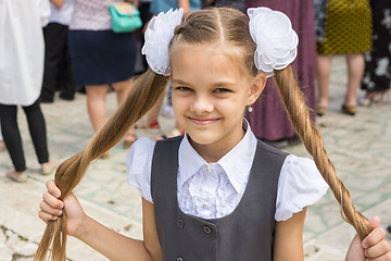 Image showing Schoolgirl at the festival on September 1 holds her long hair in her hands