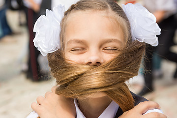 Image showing The schoolgirl on a holiday on September 1 covered her face with her long hair