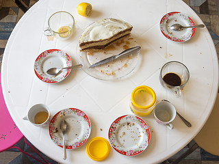 Image showing Dirty dishes and half of the homemade cake on the table