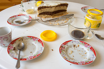 Image showing Dirty dishes on the table, homemade cake in the background