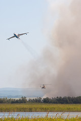 Image showing Discharge of water on a burning cane by airplane and helicopter, on a fire on the floodplains of the Anapka River, Anapa, Russia