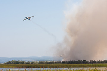 Image showing Extinguishing fire from the air using an airplane and a helicopter, with the burning of reeds on the floodplains of the Anapka River, Anapa, Russia