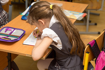 Image showing Schoolgirl with a wrong posture in class at school