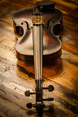 Image showing Old violin in vintage style on wood background