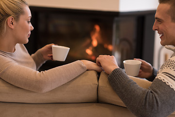 Image showing Young couple  in front of fireplace