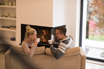 Image showing Young couple  in front of fireplace