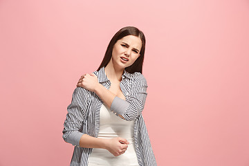 Image showing The shoulder ache. The sad woman with shoulder ache or pain on a pink studio background.