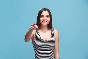 Image showing The happy woman point you and want you, half length closeup portrait on blue background.