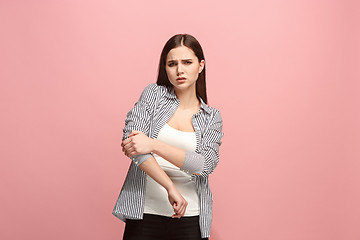 Image showing The elbow ache. The sad woman with elbow ache or pain on a pink studio background.