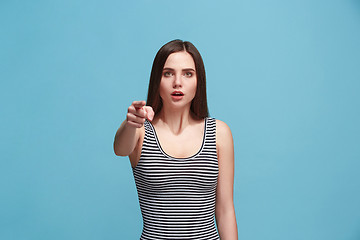 Image showing The woman point you and want you, half length closeup portrait on blue background.