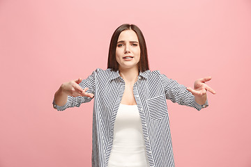 Image showing Beautiful female half-length portrait isolated on pink studio backgroud. The young emotional surprised woman