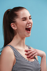 Image showing The happy woman standing and smiling against blue background.