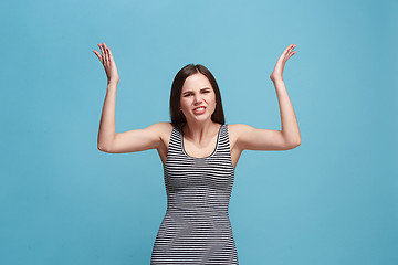 Image showing Portrait of an angry woman looking at camera isolated on a blue background