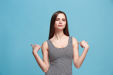 Image showing The satisfy woman standing on the blue background.