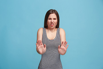 Image showing Let me think. Doubtful pensive woman with thoughtful expression making choice against blue background