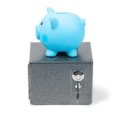 Image showing Blue ceramic piggy bank standing on a safe