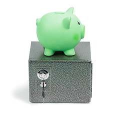 Image showing Green ceramic piggy bank standing on a safe