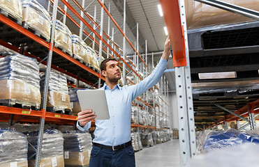 Image showing businessman with tablet pc at warehouse