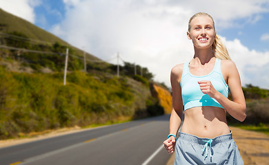 Image showing happy woman running nearby road over big sur hills