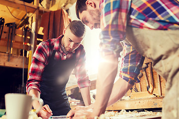 Image showing carpenters with ruler and blueprint at workshop