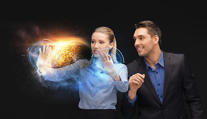 Image showing businessman and businesswoman with planet hologram