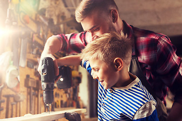 Image showing father and son with drill working at workshop