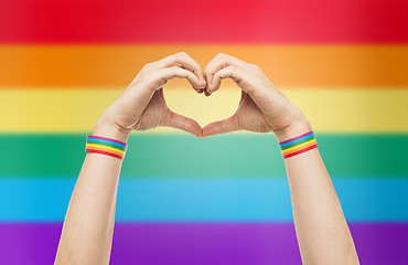 Image showing male hands with gay pride wristbands showing heart